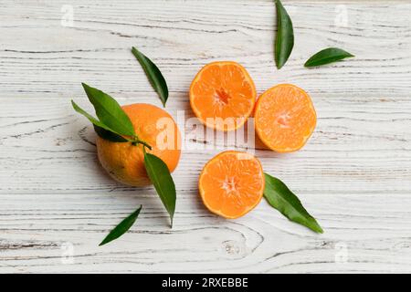 Viele frische reife Mandarine mit grünen Blättern auf farbigem Hintergrund, Draufsicht, Platz für Text. Stockfoto