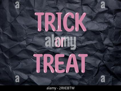 Trick or Treat auf einem schwarzen zerknitterten Papierhintergrund halloween-Konzept Stockfoto