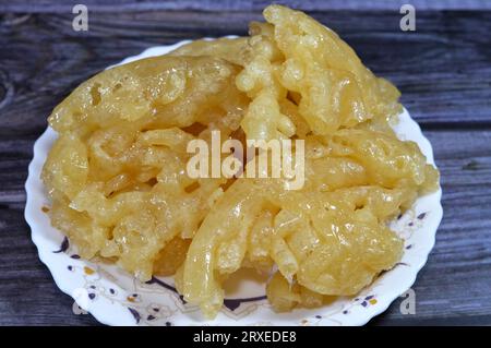 Ägyptischer Meshabek, ein abgerundeter Süßstoff aus frittiertem knusprigem Teig, der entweder in Honig oder Zuckersirup getränkt ist. Der Name wird in (verdreht) übersetzt. Stockfoto