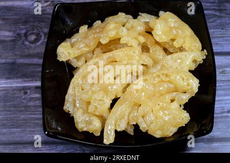 Ägyptischer Meshabek, ein abgerundeter Süßstoff aus frittiertem knusprigem Teig, der entweder in Honig oder Zuckersirup getränkt ist. Der Name wird in (verdreht) übersetzt. Stockfoto