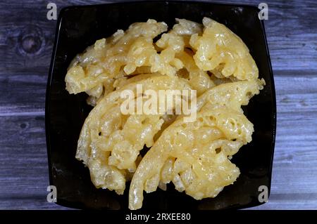 Ägyptischer Meshabek, ein abgerundeter Süßstoff aus frittiertem knusprigem Teig, der entweder in Honig oder Zuckersirup getränkt ist. Der Name wird in (verdreht) übersetzt. Stockfoto