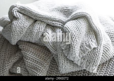 Strickpullover oder Schal in warmem Grau, gemütliche Komposition in der häuslichen Atmosphäre. Stockfoto