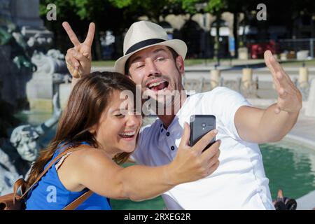 Das Paar nimmt ein abgefahrenes Selfie neben dem Brunnen Stockfoto