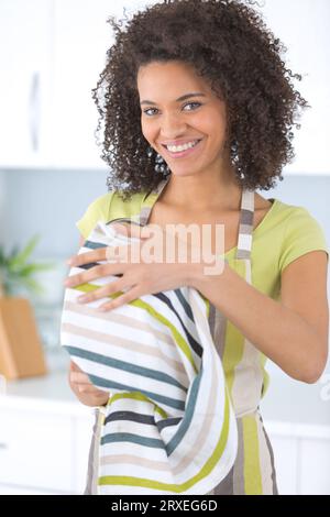 Porträt einer jungen Frau, die Geschirr trocknet Stockfoto