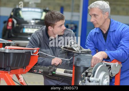 Schüler mit Lehrer, die Reparatur eines Autos während der Lehrzeit Stockfoto