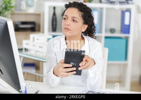 Frau, die zu Hause Rechnungen berechnet Stockfoto