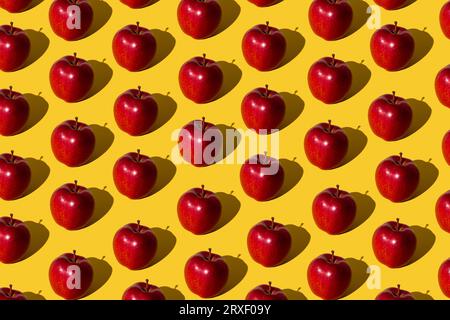 Trendiges Fruchtmuster aus roten Äpfeln auf hellgelbem Hintergrund. Minimales Konzept. Stockfoto