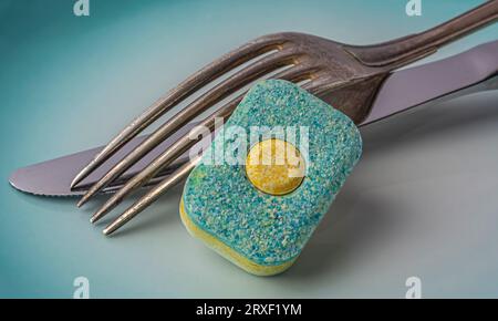 Kapselmesser und Gabel für Geschirrspüler auf blauem Hintergrund. Hochwertige Fotos Stockfoto