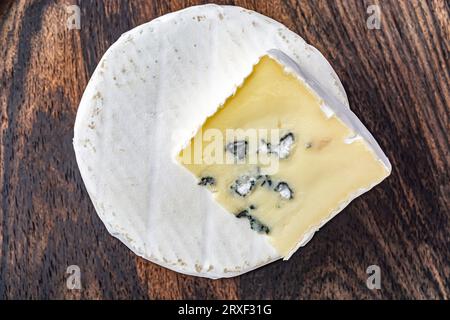 Ein Stück Blauschimmelkäse, Käse mit Schimmel auf Holzstruktur. Traditionelles französisches Essen Stockfoto