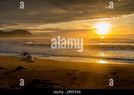 Der Sandstrand des Japanischen Meeres während des wunderschönen bunten Sonnenaufgangs in der Primorsky-Region im russischen Fernen Osten. Stockfoto
