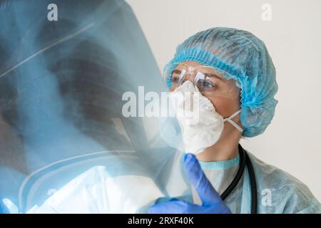 Frau Ärztin, die sich die Röntgenaufnahme der Lunge anschaut. Stockfoto