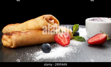 Süße Pfannkuchen mit Hüttenkäse mit Marmelade auf schwarzem Schiefer Stockfoto