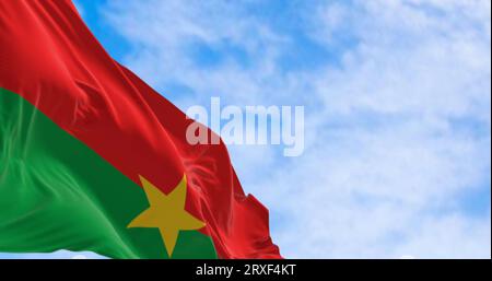 Die Nationalflagge von Burkina Faso winkt im Wind an klaren Tagen. Zwei gleiche horizontale rote und grüne Streifen mit einem gelben fünfzackigen Stern im Zentrum Stockfoto