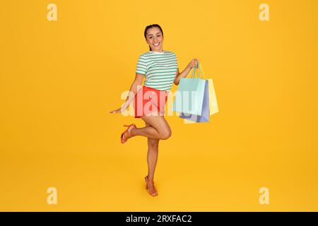 Schöne junge Dame in stilvollem Outfit mit Einkaufstaschen Stockfoto