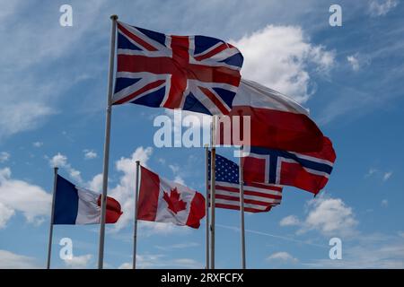 Viele verschiedene Flaggen flattern im Wind gegen den Himmel. Großbritannien Kanada England Frankreich Stockfoto