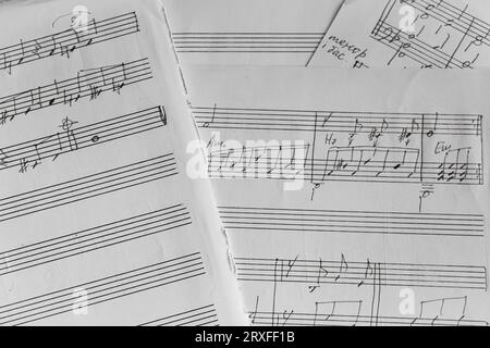 Notizen auf Papier, monochrom. Altes Notenblatt, schwarz-weiß. Melodie auf Seite. Notizen und Zeilen. Musikkonzept. Musikalische Erziehung. Tonsymbole. Stockfoto