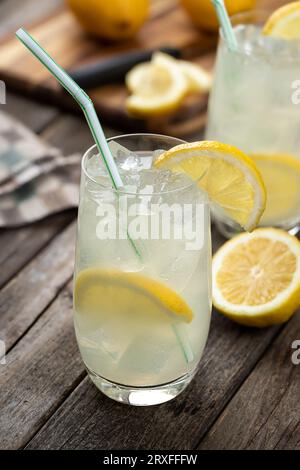 Ein Glas kalte Limonade mit Zitronenscheiben auf einem alten Holztisch Stockfoto