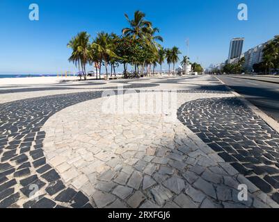 Berühmte Promenade am Copacabana Beach und Kokosnussbäume mit blauem Himmel in Rio de Janeiro Brasilien. Stockfoto