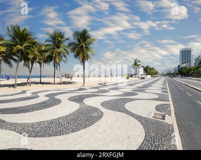 Berühmte Promenade am Copacabana Beach und Kokosnussbäume mit blauem Himmel in Rio de Janeiro Brasilien. Stockfoto