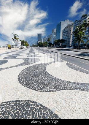 Berühmte Promenade am Copacabana Beach und Kokosnussbäume mit blauem Himmel in Rio de Janeiro Brasilien. Stockfoto