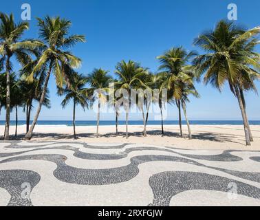 Berühmte Promenade am Copacabana Beach und Kokosnussbäume mit blauem Himmel in Rio de Janeiro Brasilien. Stockfoto