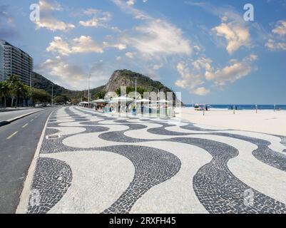 Berühmte Promenade am Copacabana Beach und Kokosnussbäume mit blauem Himmel in Rio de Janeiro Brasilien. Stockfoto