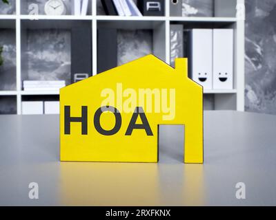 Ein gelbes Hausmodell mit HOA-Inschrift der Hauseigentümervereinigung. Stockfoto