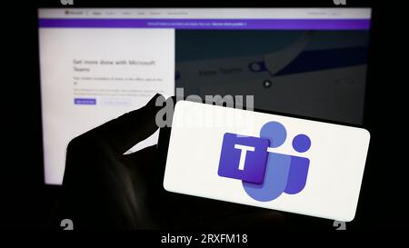 Person, die ein Smartphone mit dem Logo der Business Communication Platform hält Microsoft Teams auf dem Bildschirm vor der Website. Konzentrieren Sie sich auf das Display des Telefons. Stockfoto