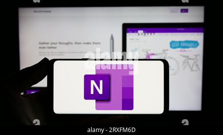 Person, die ein Smartphone mit dem Logo der Notiz-Software Microsoft OneNote auf dem Bildschirm vor der Website hält. Konzentrieren Sie sich auf das Display des Telefons. Stockfoto