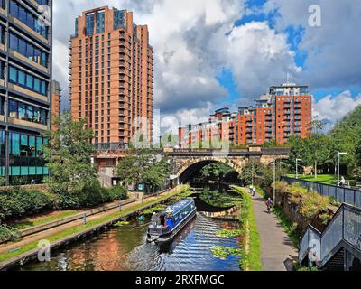 Großbritannien, West Yorkshire, Leeds, Brücke über Leeds und Liverpool Canal mit modernen Hochhausapartmentblocks im Hintergrund. Stockfoto