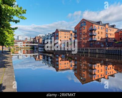 Großbritannien, West Yorkshire, Leeds, Blick nach Westen in der Nähe der Crown Point Bridge entlang des Flusses Aire, umgeben von einem Spaziergang am Fluss und modernen Waterfront Apartments. Stockfoto