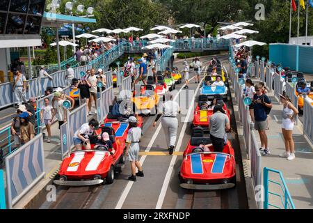 Orlando, USA - 25. Juli 2023: Besucher der Rennwagen fahren im Disney World Magic Kingdom Park. Stockfoto