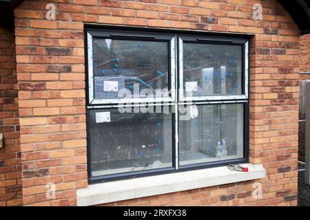 Neue Doppelverglasung-Fenster in neu gebauten Doppelhaushälften, die auf einem Anwesen in Toomebridge, Nordirland, im Bau sind Stockfoto