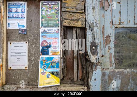 GARAGE ALTE, ALTE, VERWITTERTE GARAGE MIT ALTER TÜRKLINGEL UND VERBLASSENDER BESCHILDERUNG Stockfoto