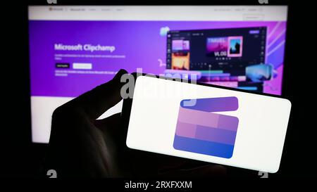 Person, die ein Smartphone mit dem Logo der Videobearbeitungssoftware Clipchamp (Microsoft) auf dem Bildschirm vor der Website hält. Konzentrieren Sie sich auf das Display des Telefons. Stockfoto