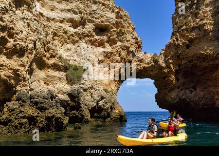 Touristen Kajak in Ponta da Piedade, Klippenlandschaft, Sandsteinklippen, Felstor, Atlantik, Lagos, Algarve, Portugal Stockfoto
