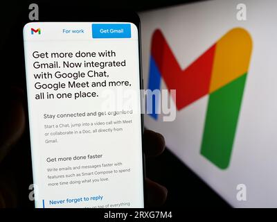 Person, die ein Smartphone mit der Webseite des E-Mail-Dienstes Google Gmail auf dem Bildschirm vor dem Logo hält. Konzentrieren Sie sich auf die Mitte der Telefonanzeige. Stockfoto