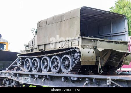 Aufnahme des alten Bauzuges, der ein Militärfahrzeug transportiert Stockfoto