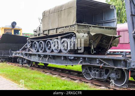 Aufnahme des alten Bauzuges, der ein Militärfahrzeug transportiert Stockfoto