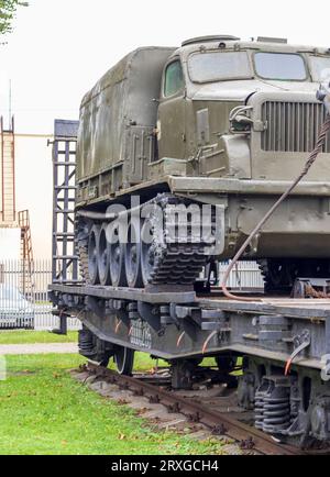 Aufnahme des alten Bauzuges, der ein Militärfahrzeug transportiert Stockfoto