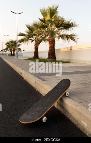 Skateboard in nuova strada deserta Stockfoto