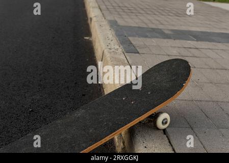 Skateboard in nuova strada deserta Stockfoto