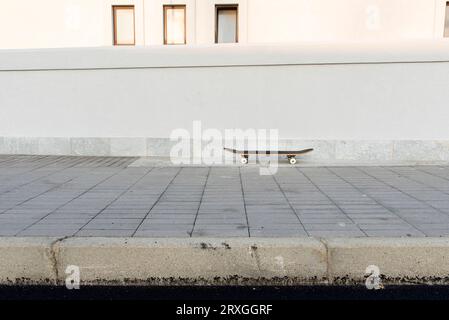 Skateboard in nuova strada deserta Stockfoto