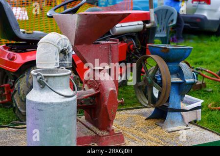 Handgeführter Crèmeabscheider aus rotem Gusseisen der 50er oder 60er Jahre und ein Milchabscheider aus Stahl neben einer Getreidemühle, Nidderdale Show, North Yorkshire, UK Stockfoto