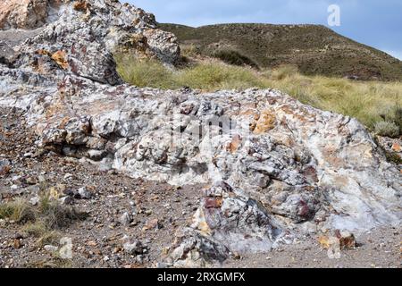 Vulkanische Felsformation Ignimbrit. Die gelben Venen sind aus Jarosite-Mineralien und rötlich aus Goethit. Dieses Foto wurde in Rodalquilar Caldera, Cabo aufgenommen Stockfoto