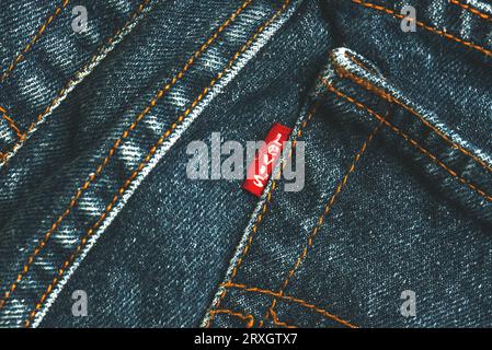 Nahaufnahme des roten Levis-Tags auf der hinteren Seitentasche. Klassische blaue Levis Jeans. Levi Strauss ist ein us-amerikanisches Bekleidungsunternehmen Stockfoto