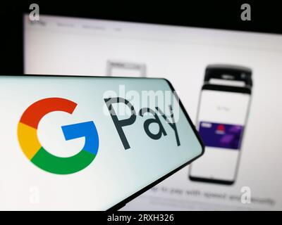 Mobiltelefon mit Logo des mobilen Zahlungsdienstes Google Pay auf dem Bildschirm vor der Business-Website. Konzentrieren Sie sich auf die Mitte-links-Anzeige des Telefons. Stockfoto