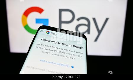 Mobiltelefon mit Website des mobilen Zahlungsdienstes Google Pay auf dem Bildschirm vor dem Firmenlogo. Konzentrieren Sie sich auf die obere linke Ecke des Telefondisplays. Stockfoto