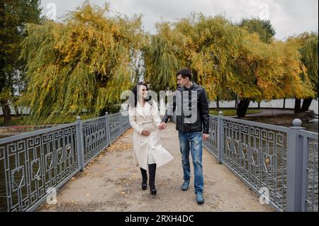 Ein Mann geht mit seiner schwangeren Frau im Park spazieren Stockfoto