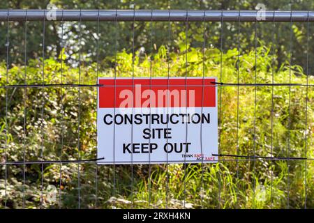 Halten Sie das Schild am Metallzaun einer Baustelle fern. Keine Personen. Stockfoto